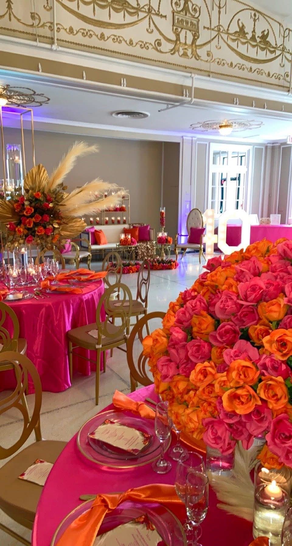 Pink and orange luxury event design with lush florals, gold chairs and vibrant tablescapes